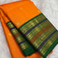 Folded view of marigold orange Kanchipuram saree with green, violet and brick-toned layered zari border.