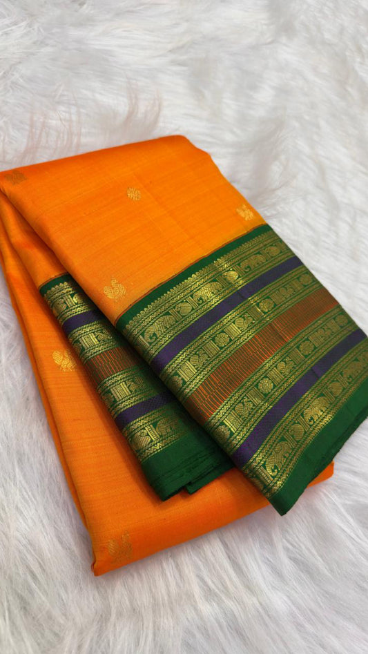 Folded view of marigold orange Kanchipuram saree with green, violet and brick-toned layered zari border.