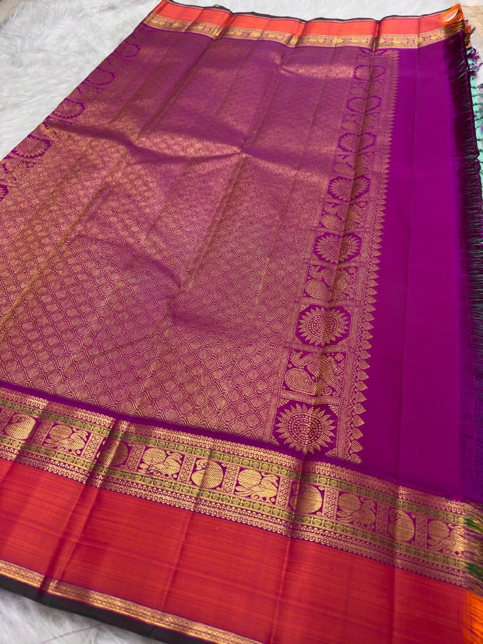Handwoven mint-green Korvai Kanjipuram saree with jewel-purple and coral-orange contrast.