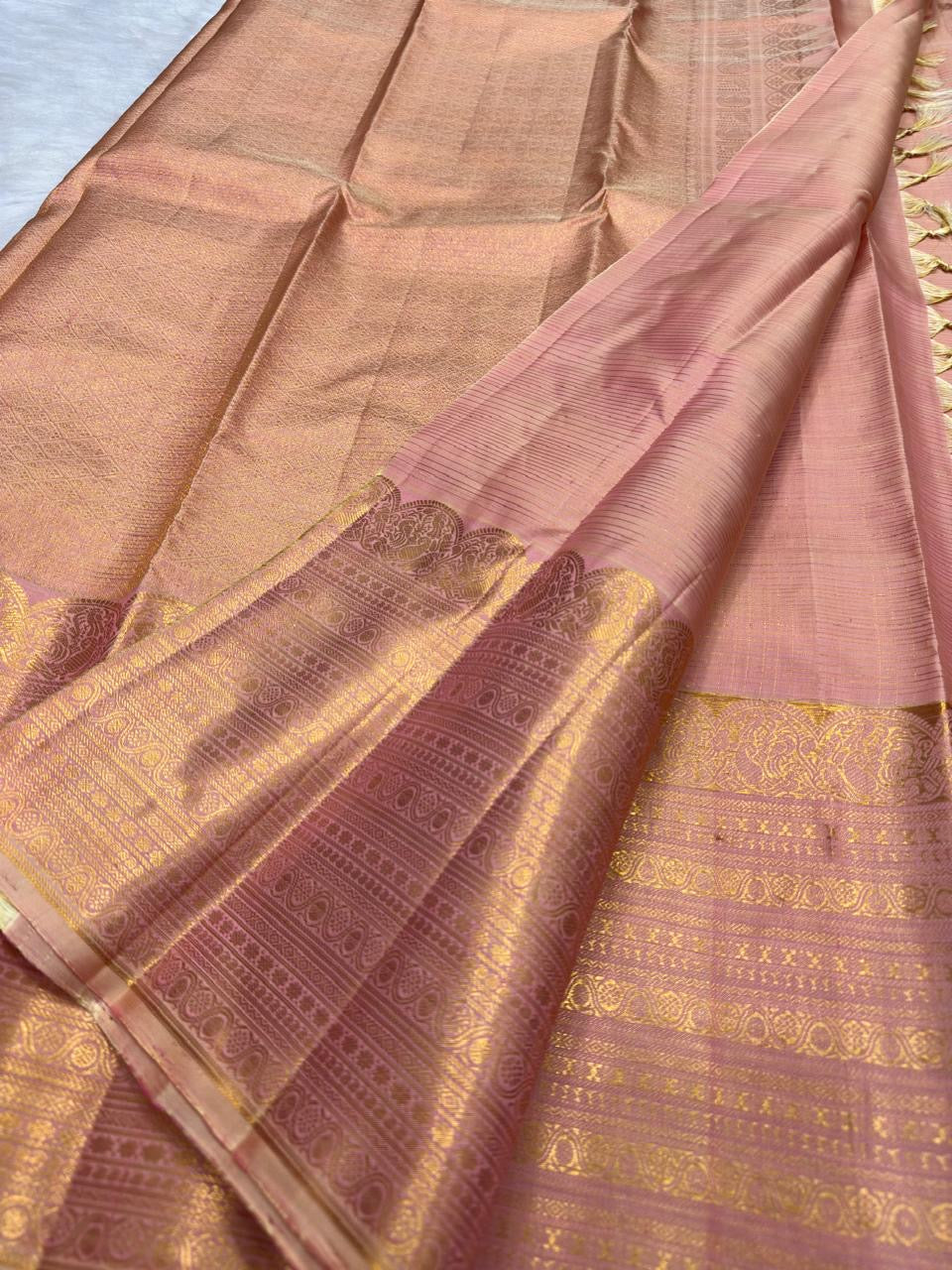 Handwoven Soft Peach Blush Pure Silk Kanchipuram Zari Kattam saree draped to show the fine gold checked body and antique-gold border.