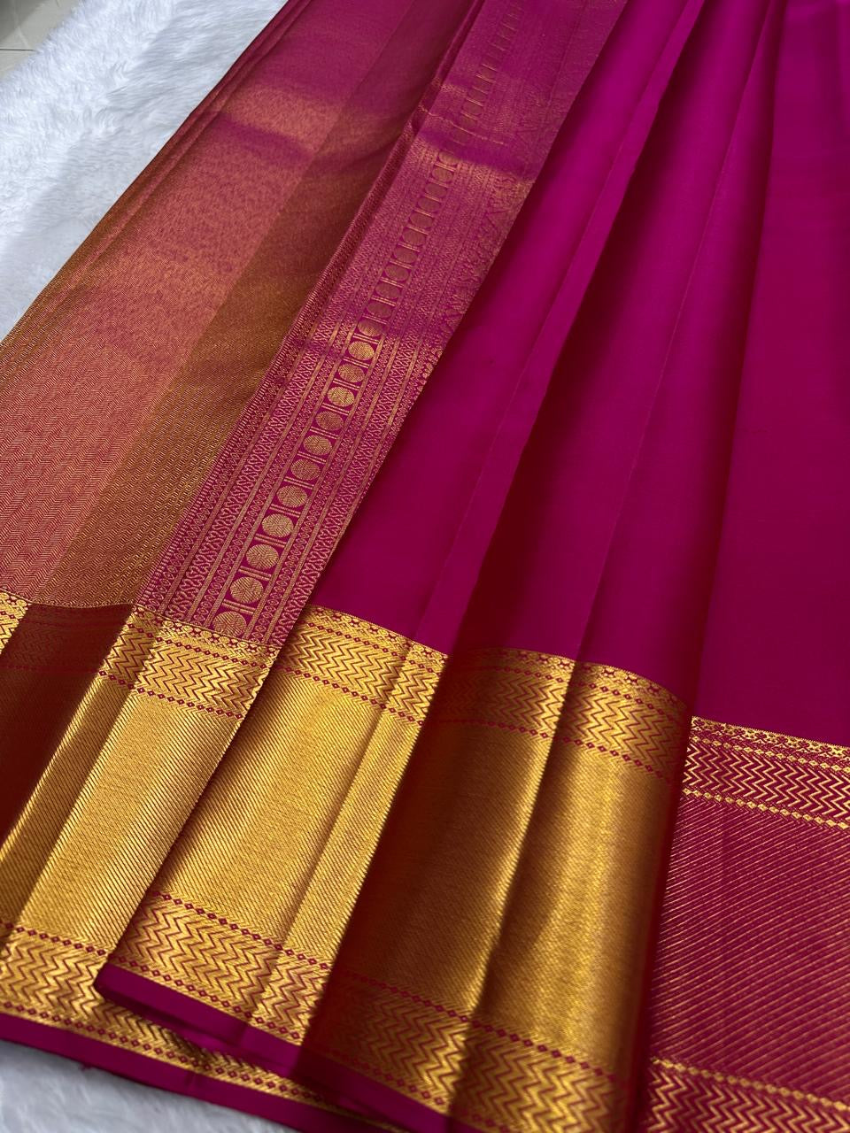 Raspberry pink Kanjeevaram saree draped showing zari kattam weave
