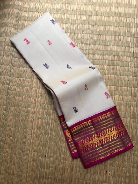 Handwoven ivory Pure Kanjivaram Korvai silk saree with peacock silk thread buttas