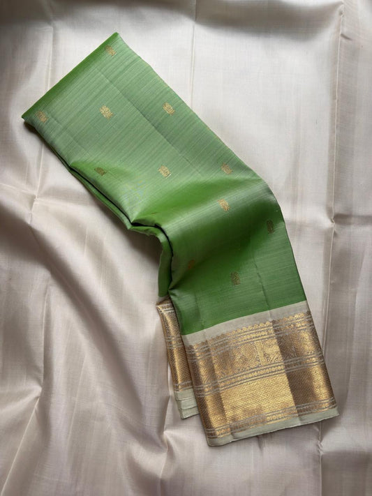 Handwoven pistachio green Kancheepuram saree with silver Korvai border.