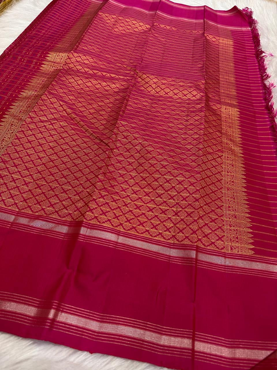 Front view of the raspberry pink KanchiPattu saree with its dense 1000 Butta weave.