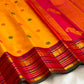 Handwoven golden turmeric Kanchipuram saree with raspberry pink zari border.