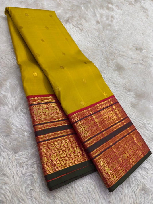 Turmeric Gold Kanjivaram silk saree with raspberry Korvai border