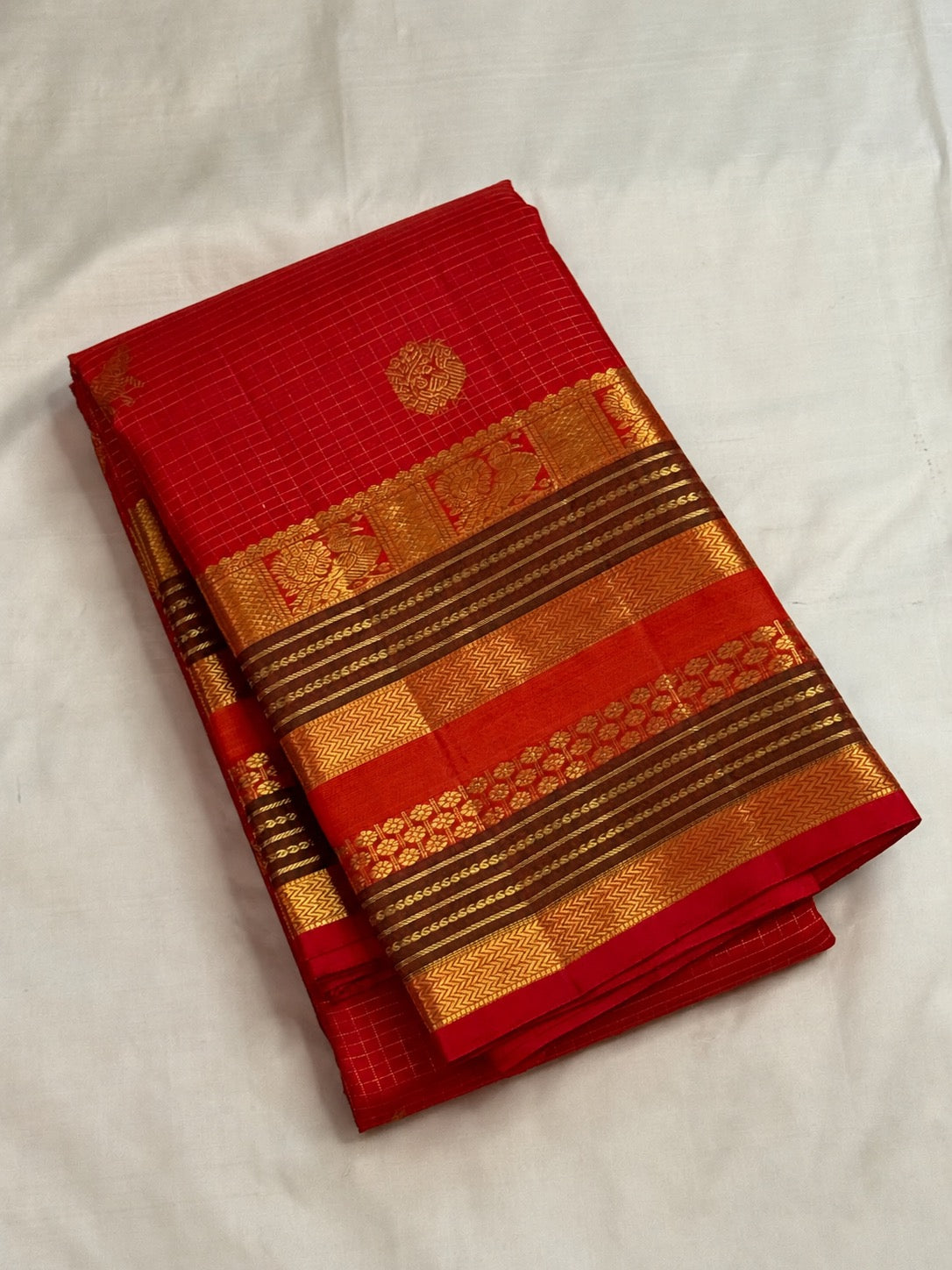 Radiant vermilion red reminiscent of temple kumkum pure silk Kanchipuram saree, handwoven red zari checks saree; traditional Zari Kattam weave.