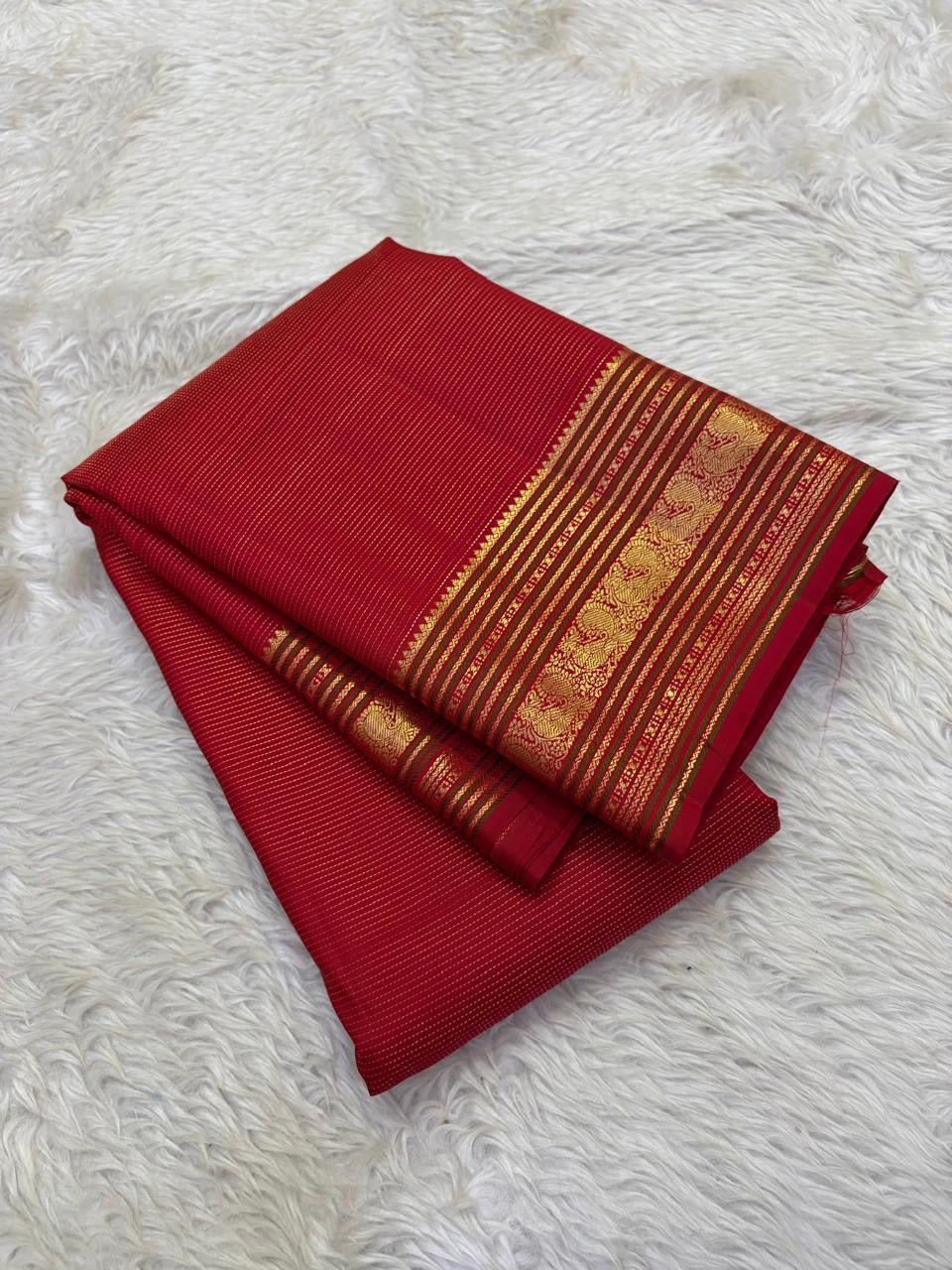 Stacked folded red vairaoosi Kanchipattu saree with gold zari varisaipet border Idam Living