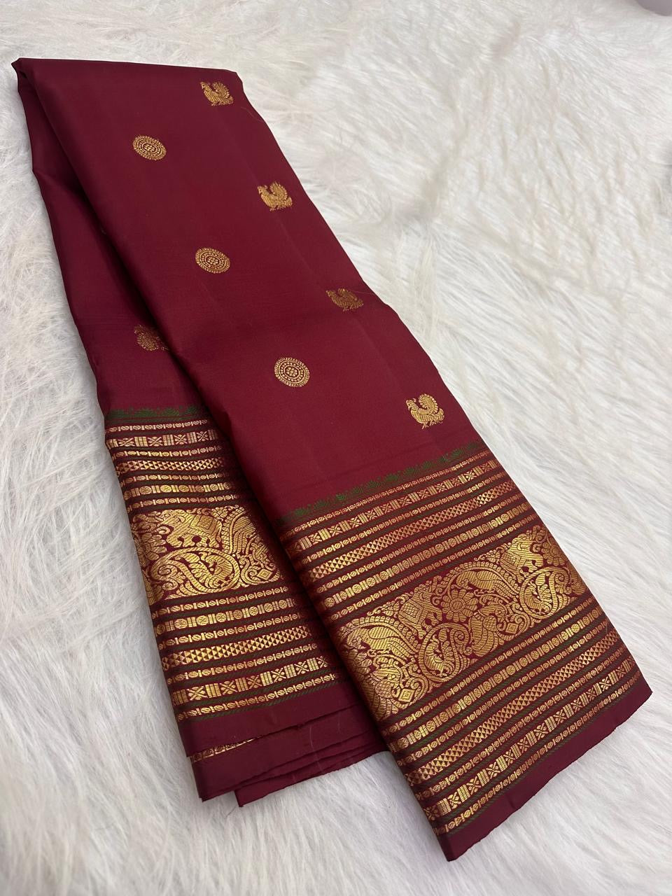 Handwoven deep red Kanchipuram Varisaipet silk saree with an ornate gold-zari border.