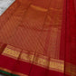 Small gold zari buttas across glowing Sindoor red Kanjipuram silk with delicate lattice weave