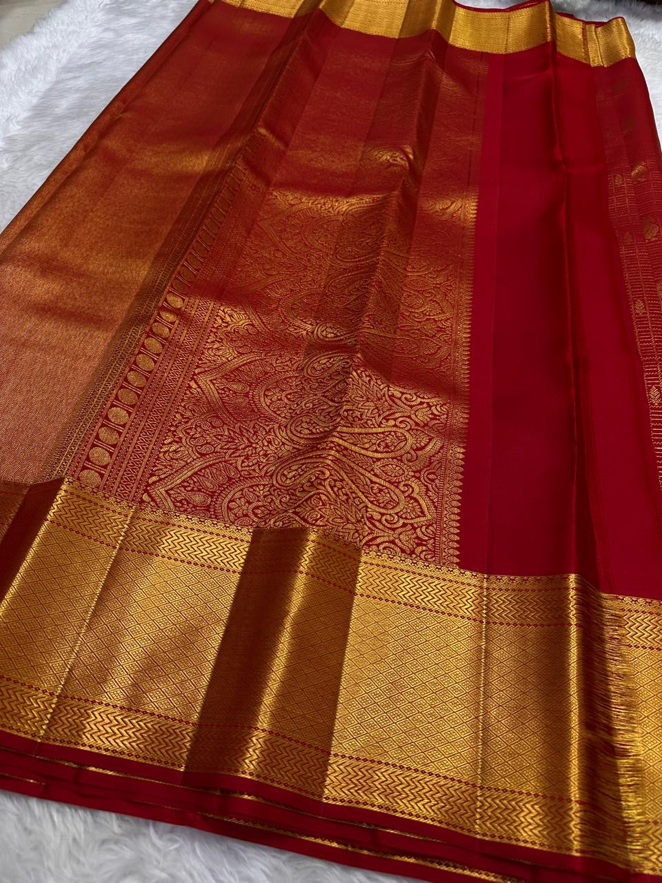 Pillar box red Kancheepuram saree draped, showing zari kattam grid weave