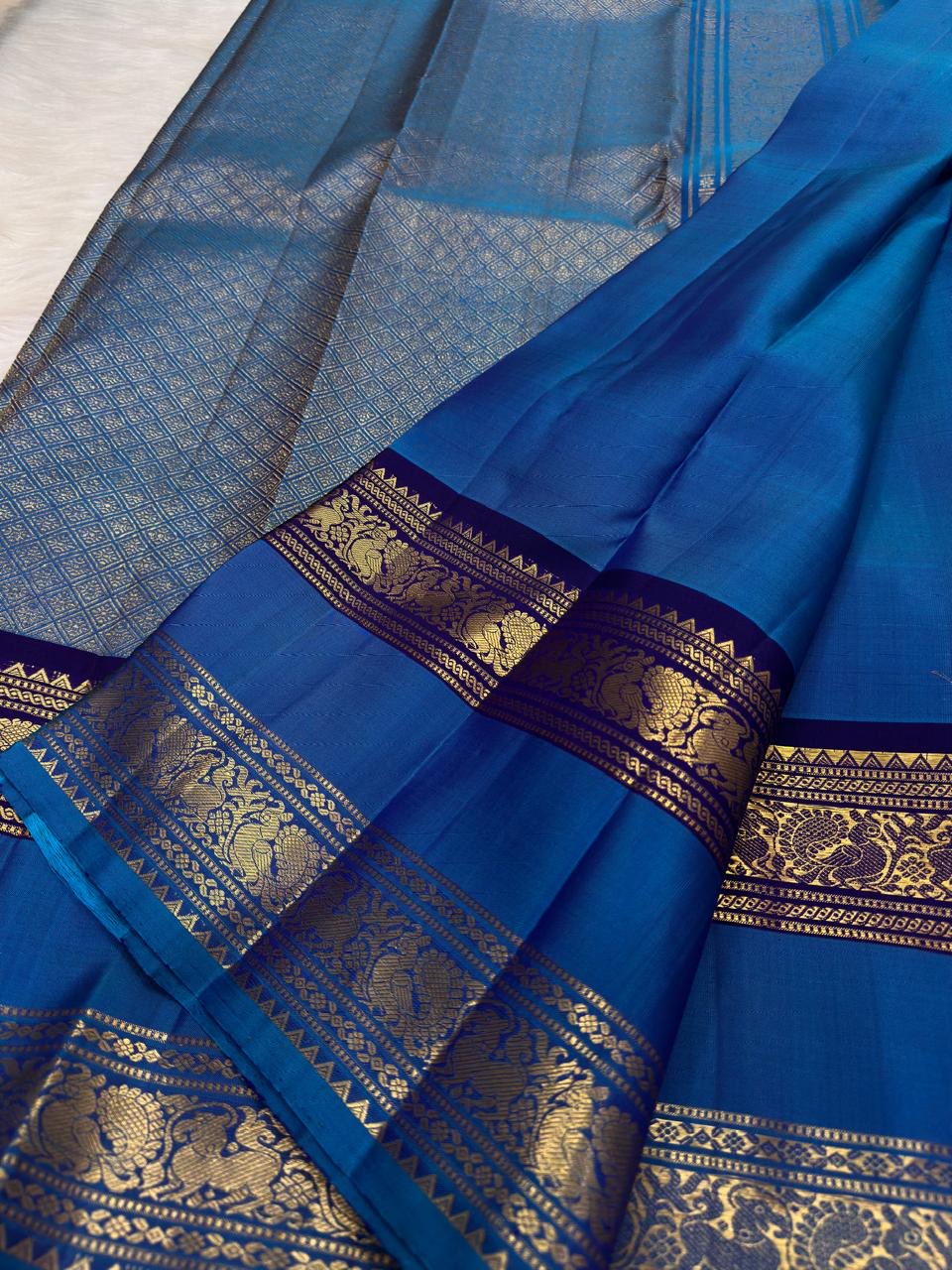Handwoven Rettapet saree in royal azure blue with purple border, draped view