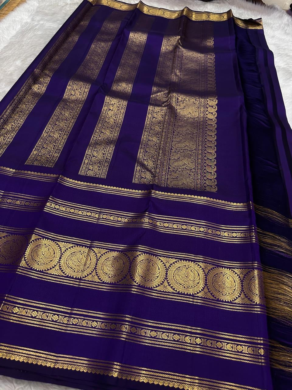 Handwoven royal violet Kanchipattu saree with Rettapet zari border, folded view.