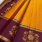 Handwoven turmeric gold Kanchipuram silk rettapet saree with Vadamalli plum border.