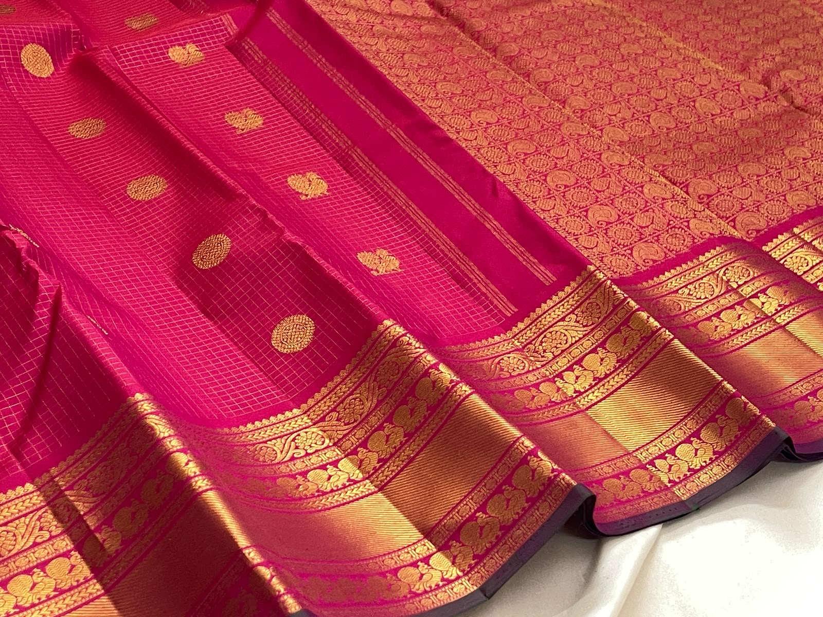 Handwoven Zari Kattam saree in fuchsia pink with Mayil Chakram motifs, styled view