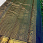 Handwoven Zari Kattam saree in royal teal blue with Mayil Chakram motifs, styled view