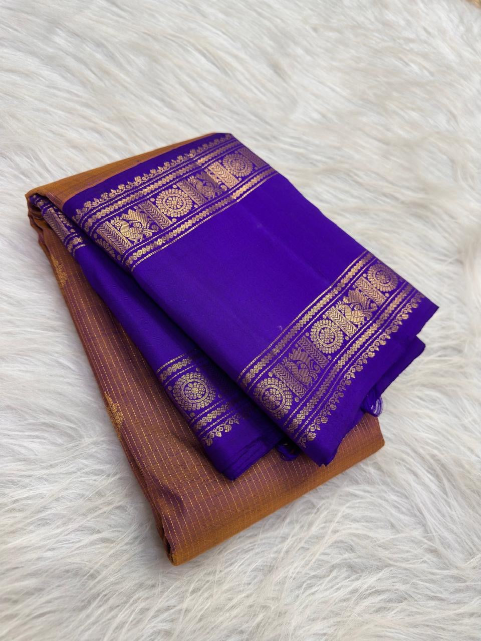 Close view of small gold buttas spaced across the sandalwood copper and royal violet silk