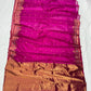Purplish pink Katan silk Chanderi saree laid open showing small gold-toned buttas and broad antique-gold floral border with turquoise accents