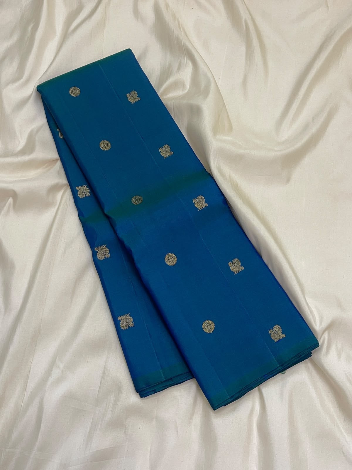 Peacock blue Kanchipuram silk saree with teal-green cast and widely spaced small gold zari buttas