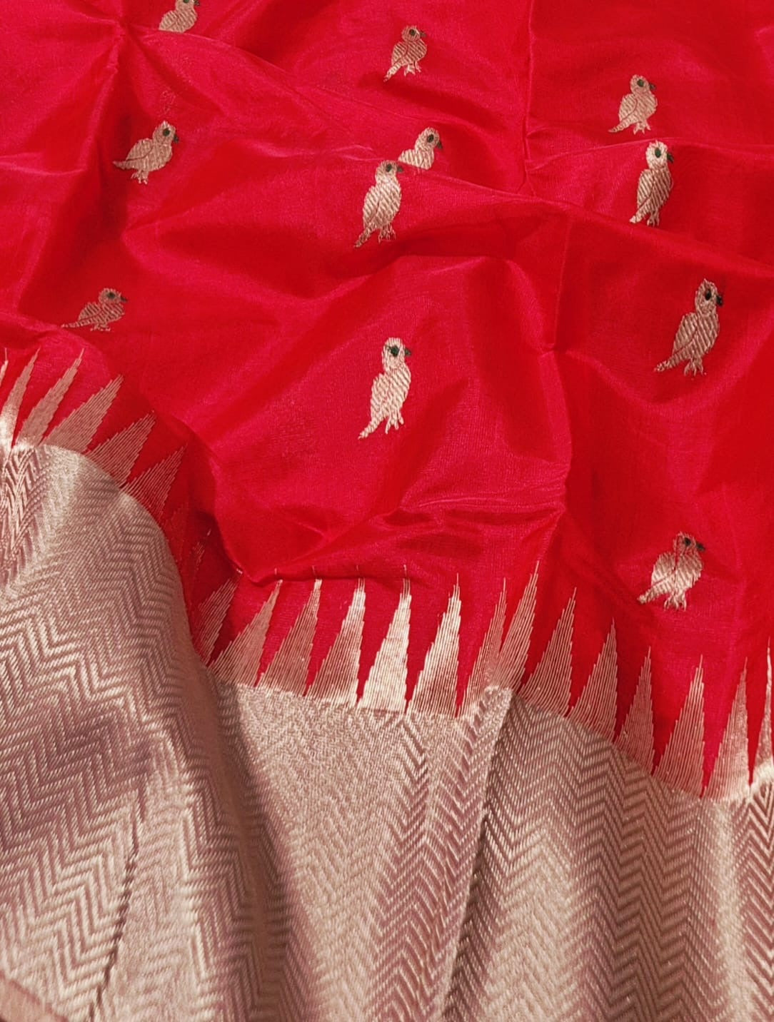 Close-up of golden Minakari parrot buttas on hibiscus red Chanderi saree body