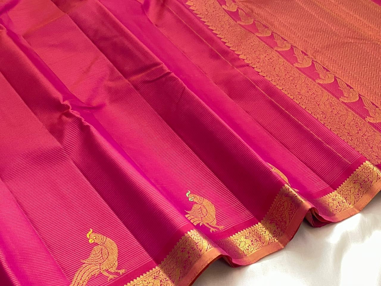 Gold zari temple motif border detail of handwoven hot pink and copper KanchiPattu pure silk saree