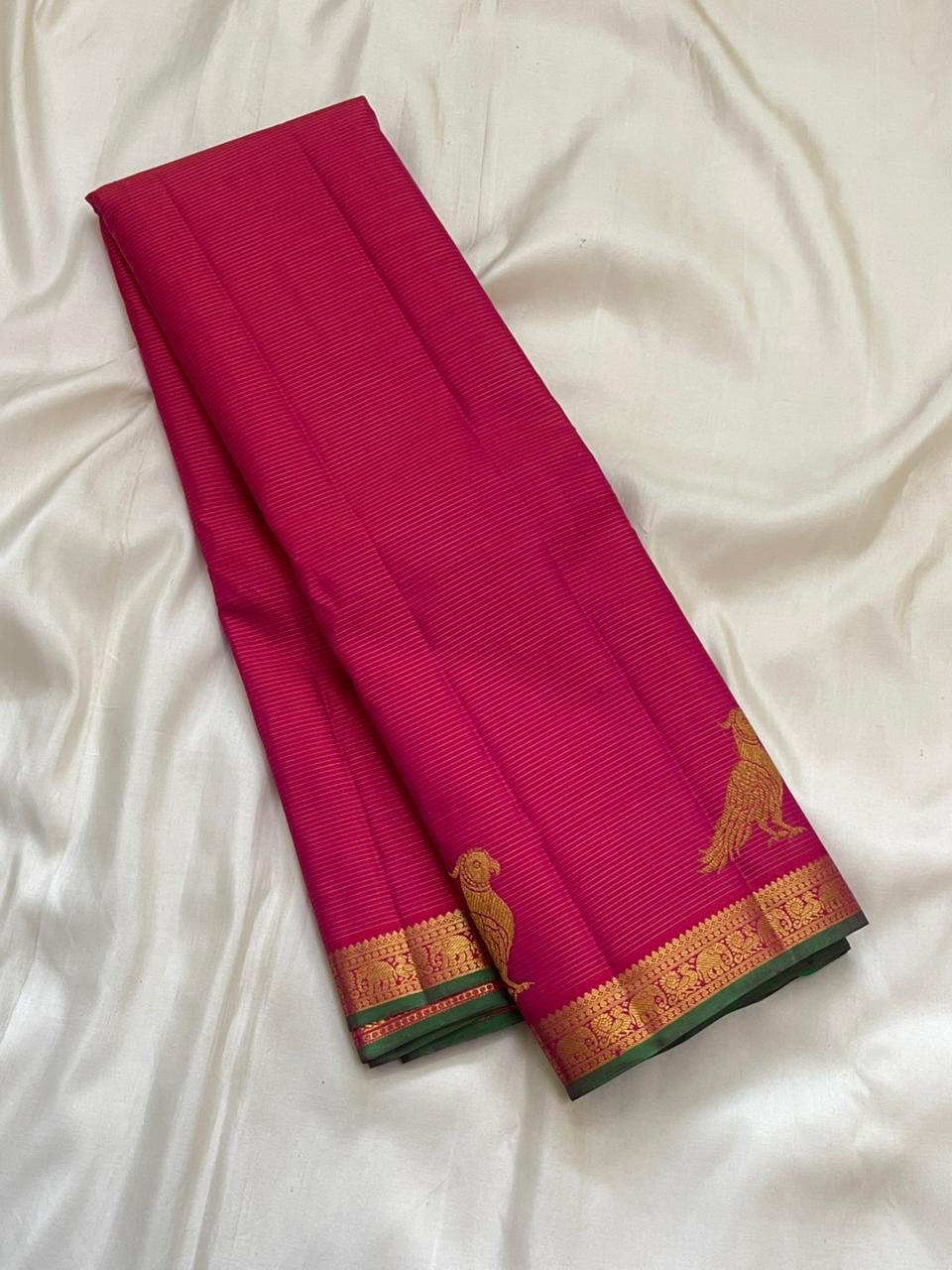Close view of hot pink Kanchipuram silk body with fine Vairaoosi zari lines running horizontally across the field