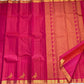 Folded hot pink KanchiPattu pure silk saree showing Vairaoosi zari shimmer body and copper contrast border