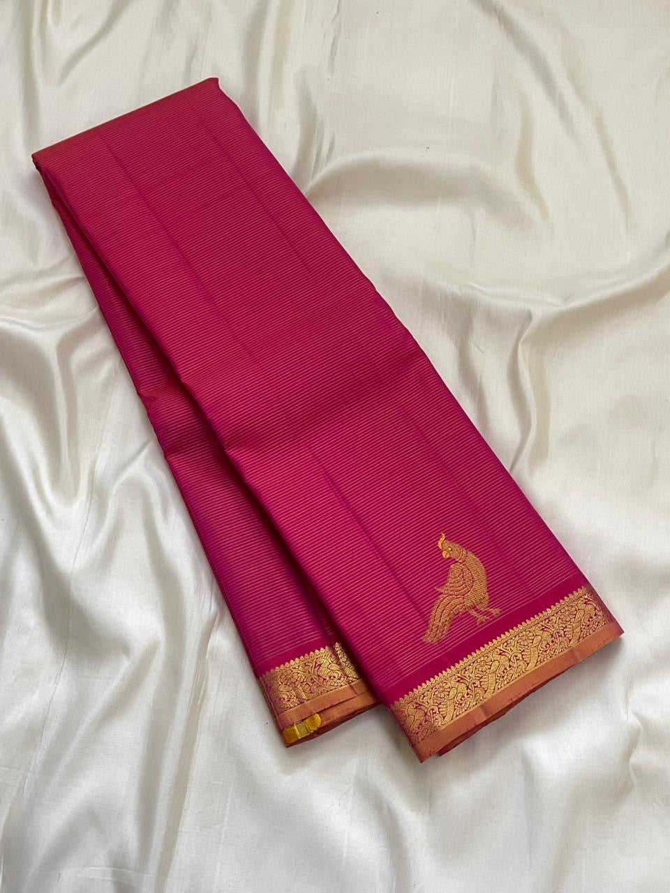 Copper gold zari border of hot pink KanchiPattu pure silk saree with classical temple motif frieze