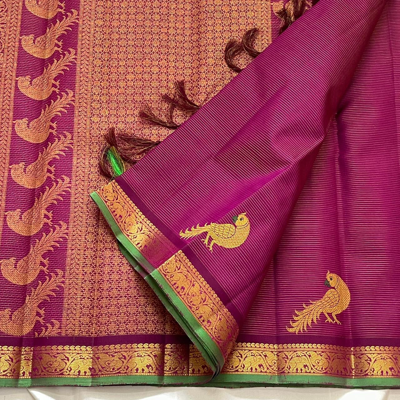 Gold zari temple motif border detail of handwoven hot pink and green Kanjipuram pure silk saree