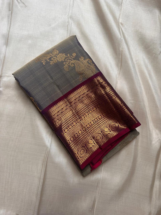 Pure Kanchipuram silk saree in grey taupe featuring traditional kodi butta motifs with deep purple border woven in gold zari