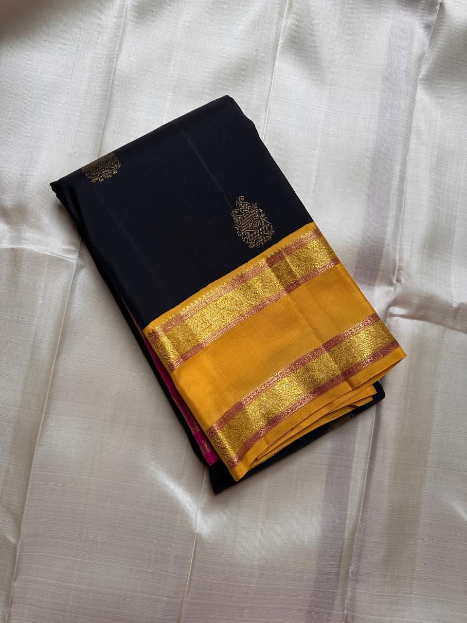 Traditional navy blue silk saree with antique gold zari buttas and dual tone Ganga Jamuna border