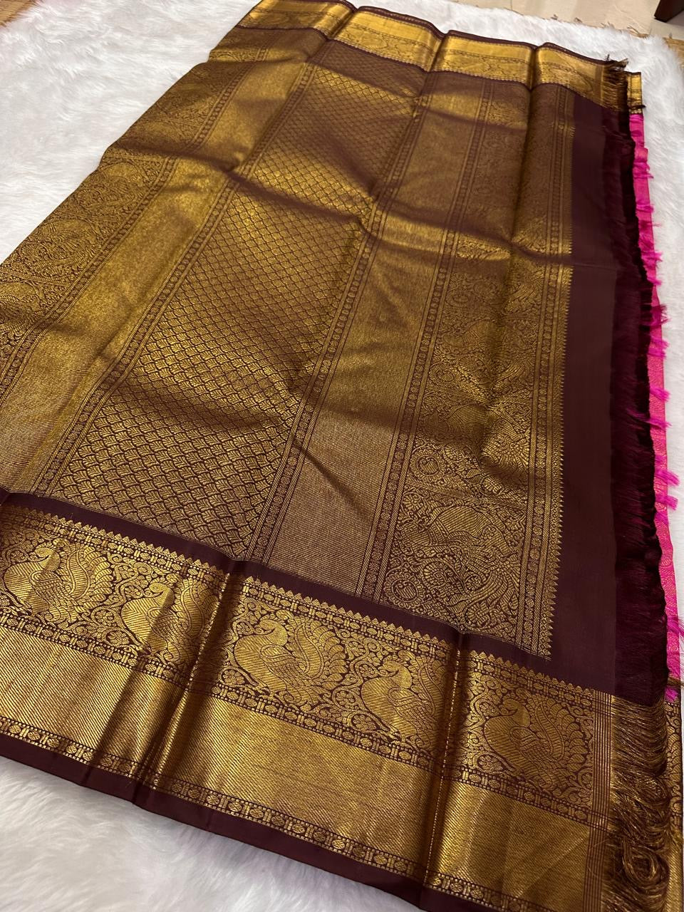 Brown and gold traditional saree with intricate patterns on a white background