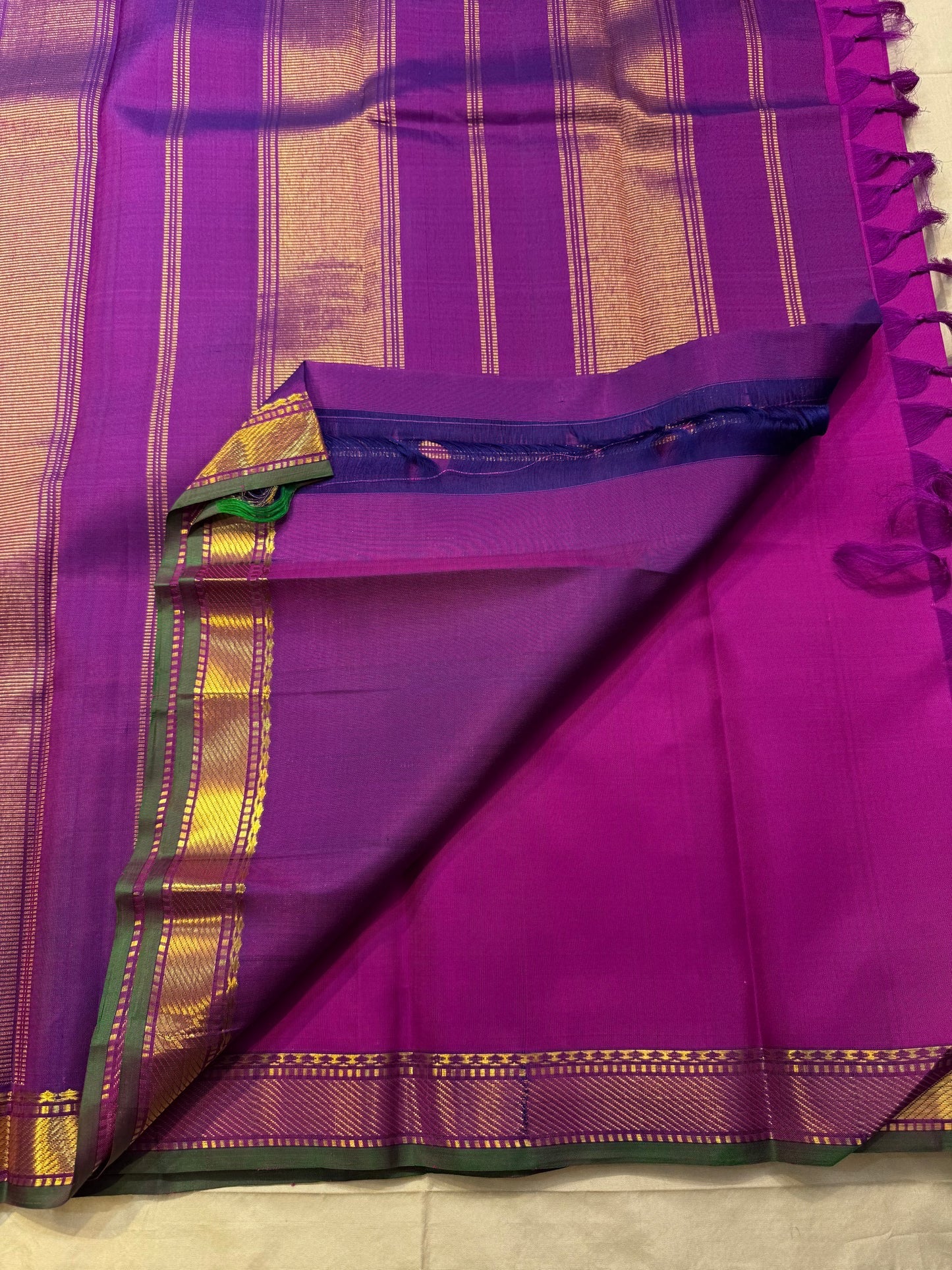 Traditional Kanchi Pattu silk saree with floral buttas, emerald green zari border, and richly woven seer pallu