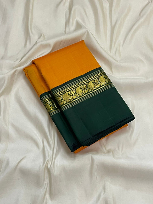 Vibrant mustard green Kanchipuram silk saree folded view with ivory border and antique gold zari