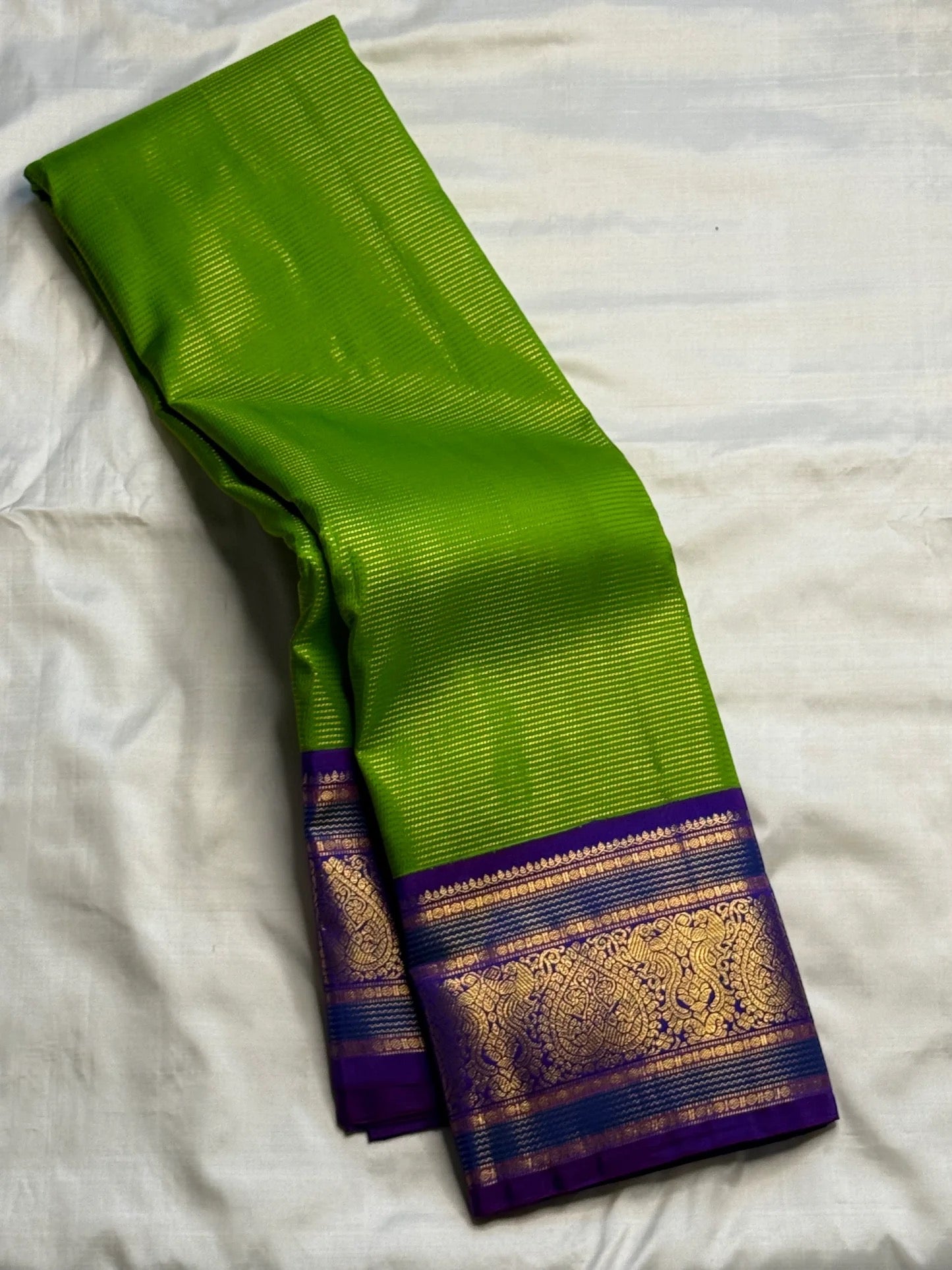 Close view of antique-gold ornamental weaving on the Royal Purple Korvai border.