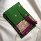 Handwoven green Kanchipuram silk saree with antique-gold zari buttas and purple border.