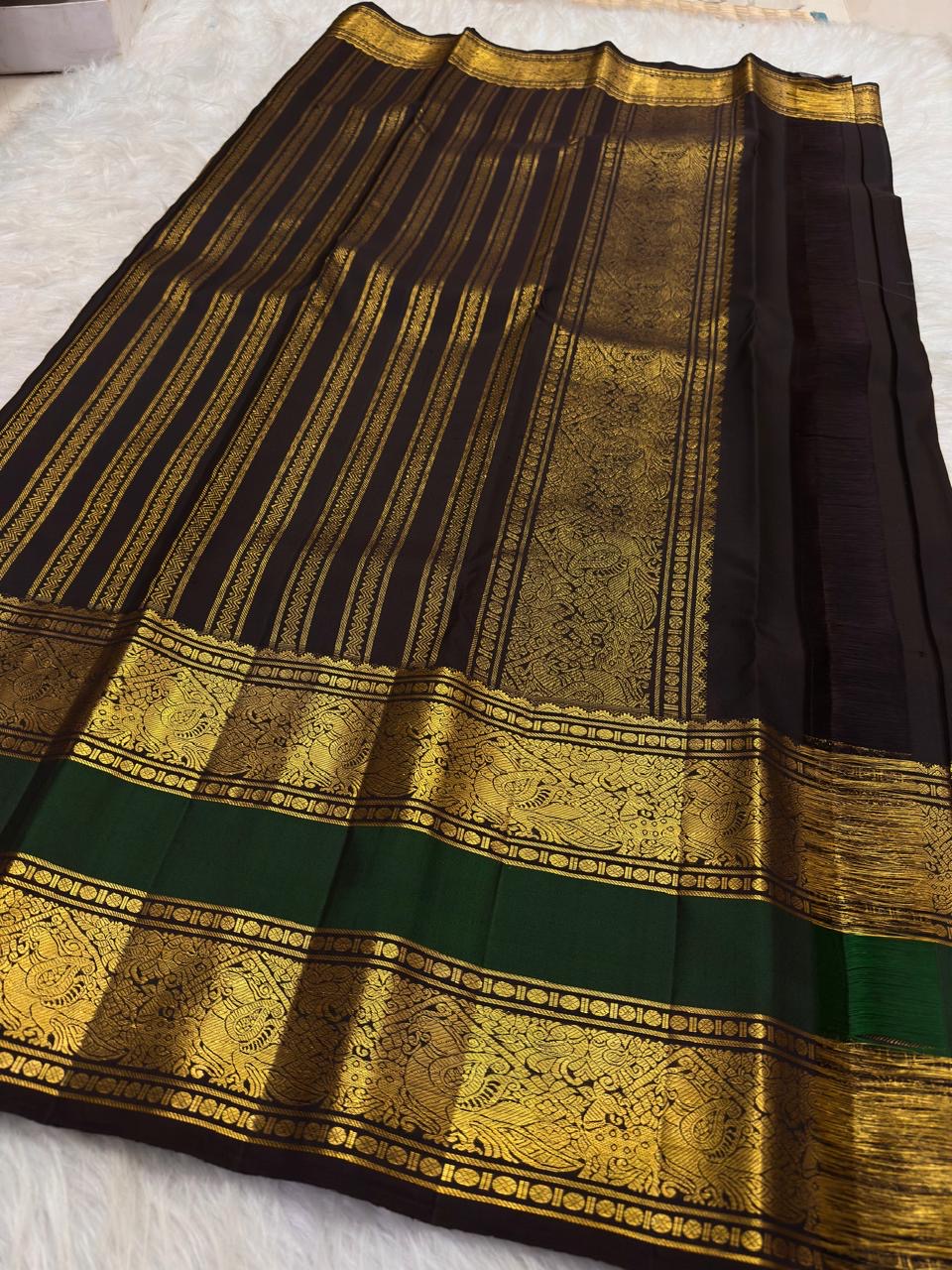 Full spread of deep brown × bottle green Kanchipuram silk showing body, twin zari border and grand pallu arrangement