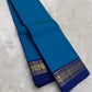 Ink blue Pure Kanchipuram Silk Saree drape with navy zari border and gold zari pattern on white fur background
