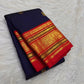 Deep navy Kanchipuram silk saree with spaced gold zari motifs and layered red Varisaipet border.