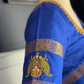 Blue saree with gold border on a mannequin against a neutral background