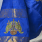 Blue saree with intricate gold and green embroidery on a white background