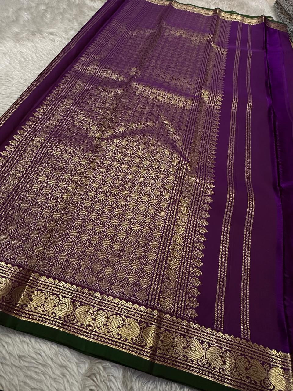 Wide pallu layout in deep purple with rich gold zari woven work and border, available in the USA.