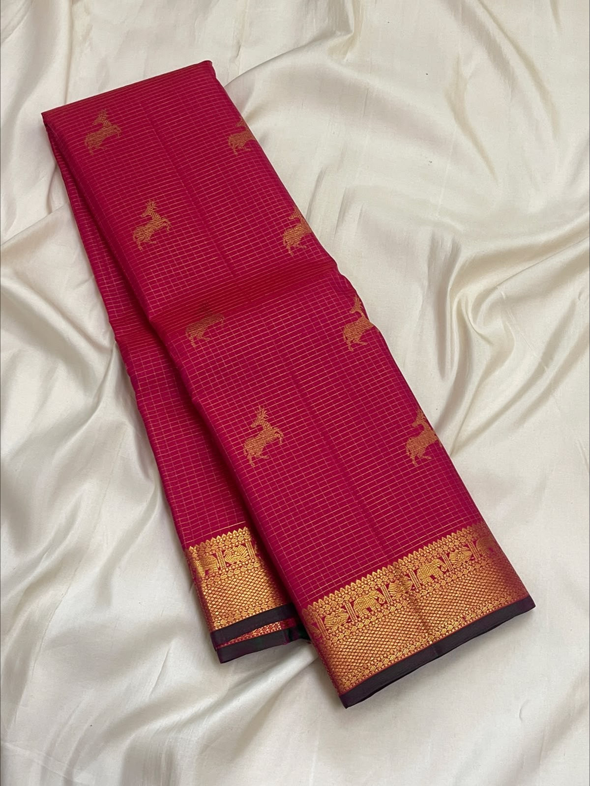Close view of deer motifs and fine zari kattam checks on a deep pink Kanjivaram silk body