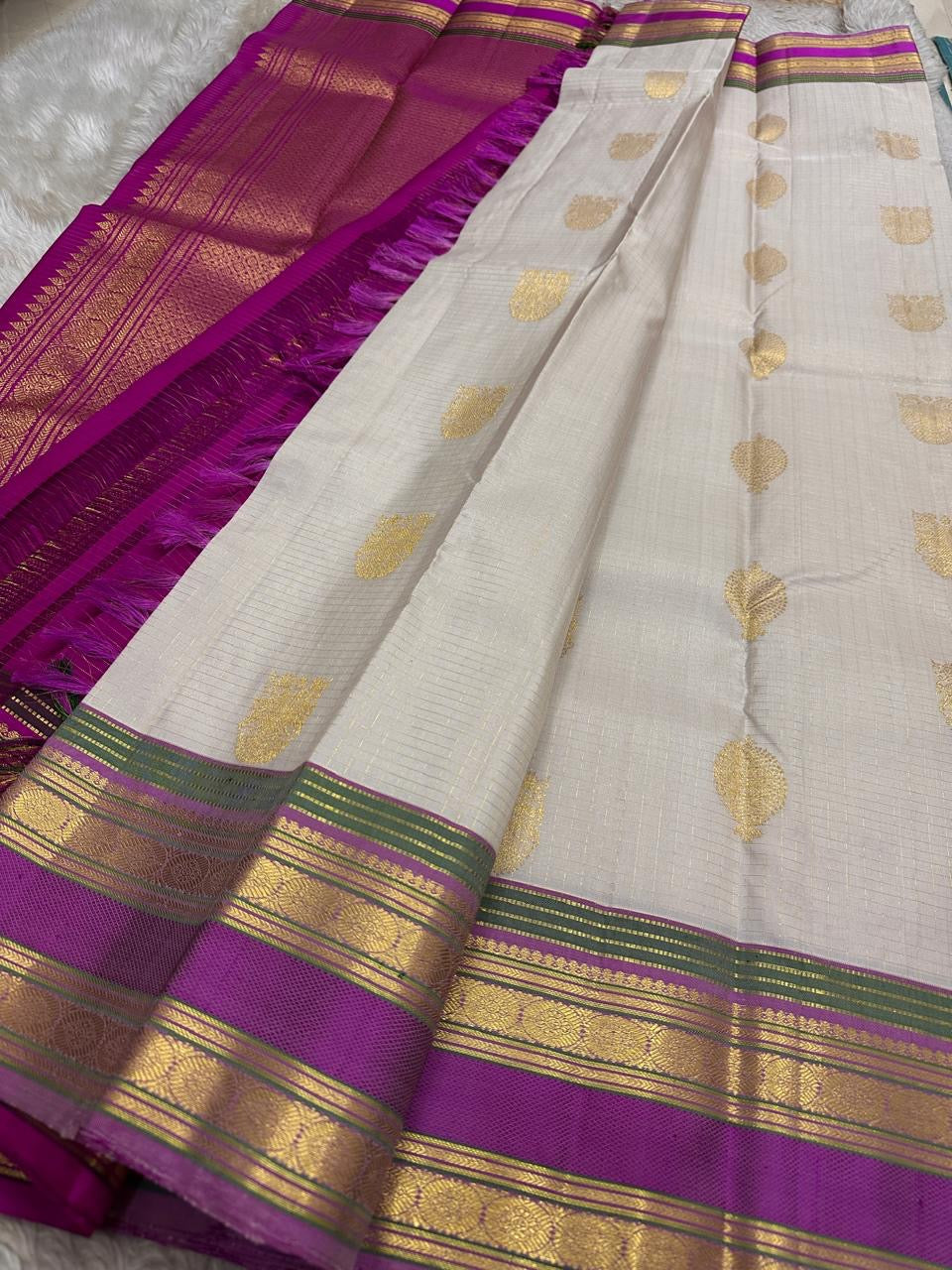 Flat lay of pearl silver pure Kanchipuram silk saree with gold paisley buttas and magenta zari border, shipped from New Jersey USA