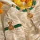 Macro detail of kundan choker medallion on cream silk velvet with green bead band and pearl clusters