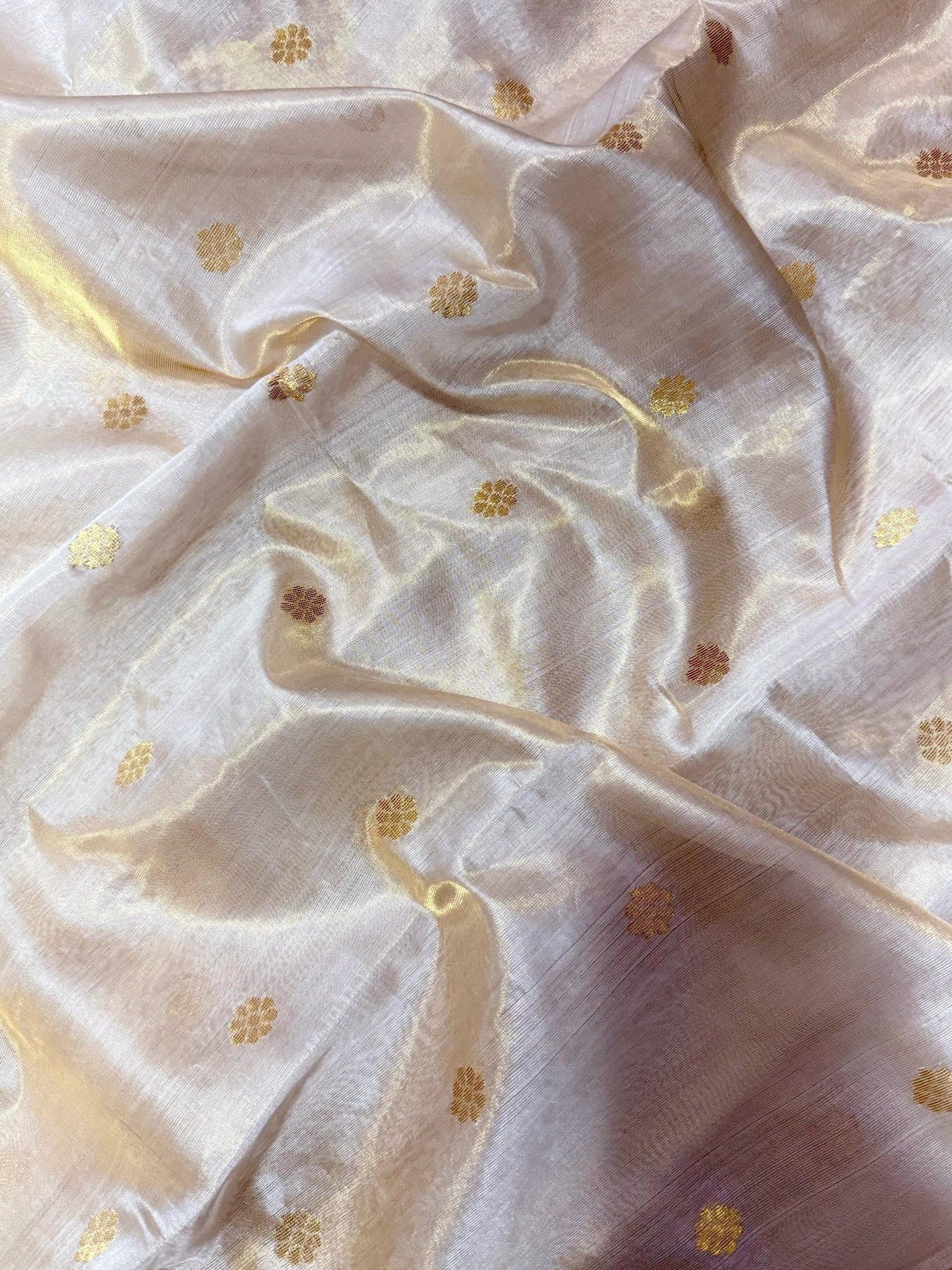 Close view of translucent ivory Chanderi silk surface with fine antique gold zari accents