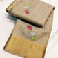 Folded champagne beige Pattu silk Chanderi saree with multicolour floral buttas and broad gold border