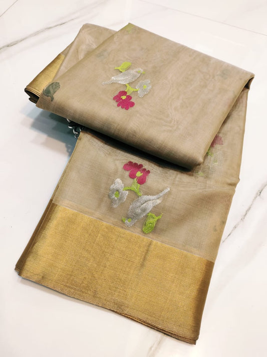 Folded champagne beige Pattu silk Chanderi saree with multicolour floral buttas and broad gold border