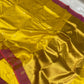 Turmeric yellow Pattu silk Chanderi saree showing the golden woven pallu and raspberry pink edge