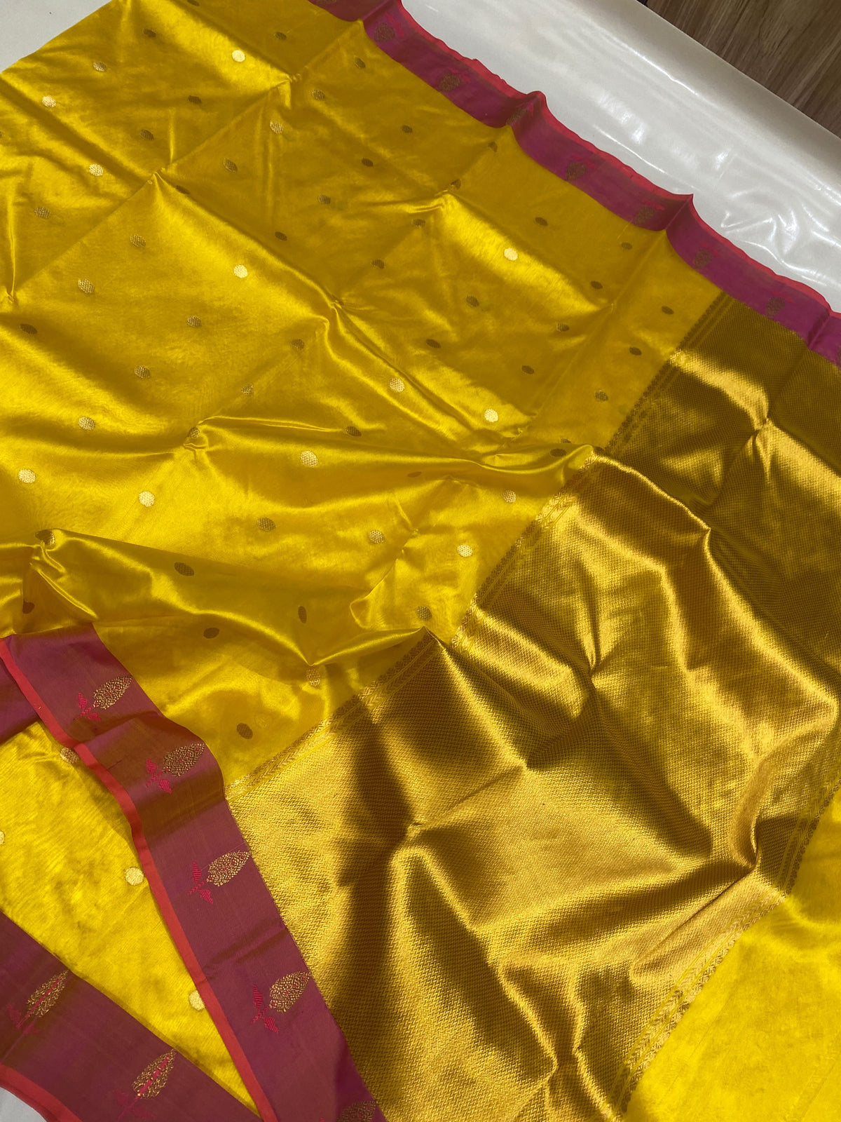 Turmeric yellow Pattu silk Chanderi saree showing the golden woven pallu and raspberry pink edge